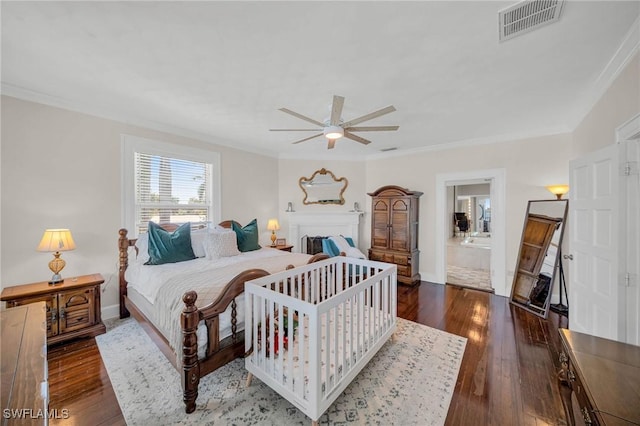 bedroom with ceiling fan, dark hardwood / wood-style flooring, crown molding, and connected bathroom