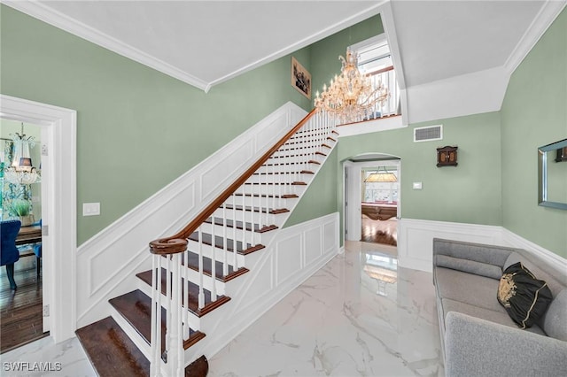 stairs with a notable chandelier and crown molding