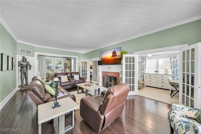 living room featuring a fireplace, french doors, wood-type flooring, and ornamental molding