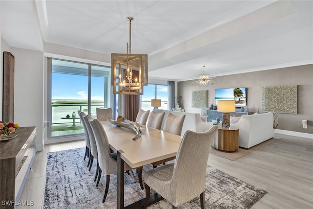 dining space with a wealth of natural light, a chandelier, and a water view