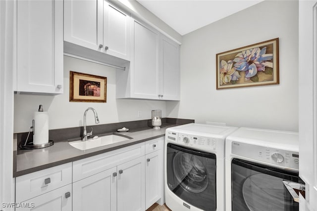 laundry room featuring cabinets, sink, and washing machine and clothes dryer