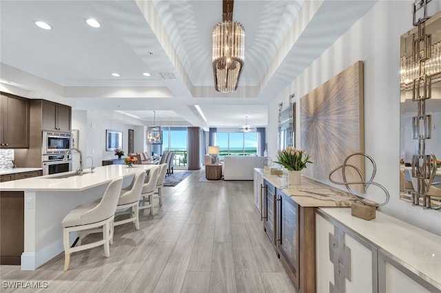 kitchen featuring stainless steel appliances, a kitchen bar, and an inviting chandelier