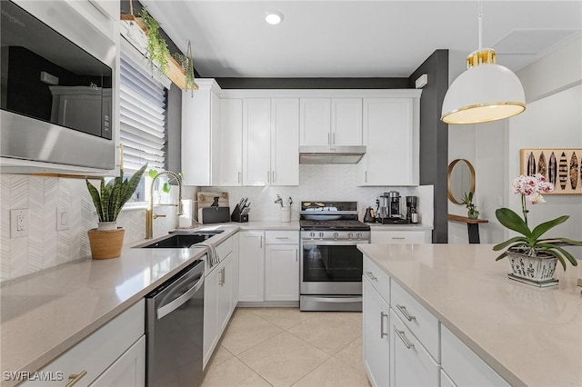 kitchen with appliances with stainless steel finishes, tasteful backsplash, white cabinetry, and sink