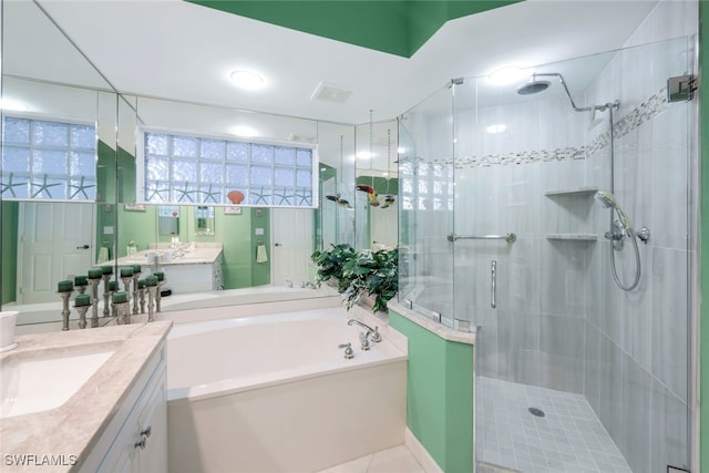 bathroom with tile patterned flooring, vanity, and shower with separate bathtub