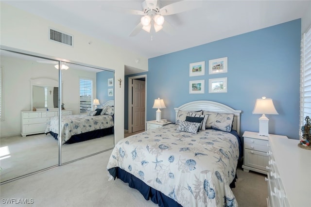 bedroom featuring light carpet, a closet, and ceiling fan