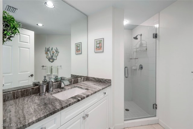 bathroom featuring tile patterned flooring, vanity, and a shower with door