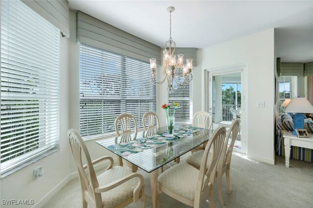 dining area with light carpet and an inviting chandelier