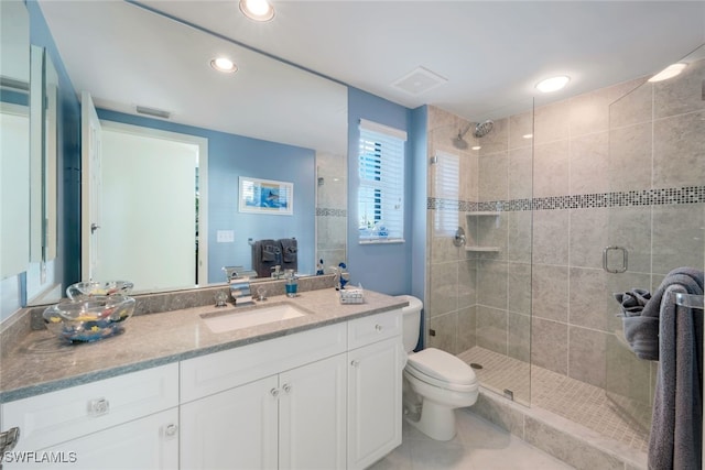 bathroom featuring tile patterned floors, vanity, toilet, and an enclosed shower