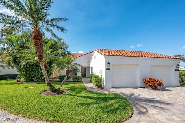 mediterranean / spanish house with a front yard and a garage