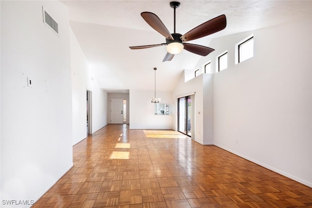 empty room featuring ceiling fan, light parquet flooring, high vaulted ceiling, and a healthy amount of sunlight