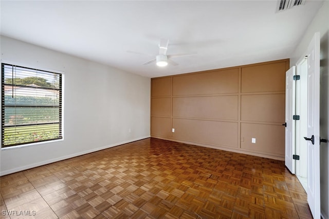 empty room with dark parquet flooring and ceiling fan