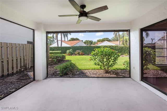 unfurnished sunroom featuring ceiling fan and plenty of natural light