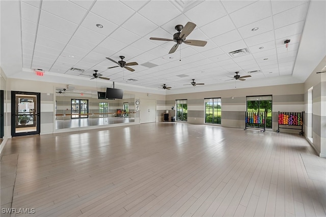 interior space with a paneled ceiling and light hardwood / wood-style flooring