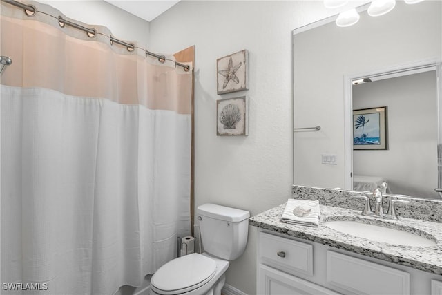 bathroom featuring vanity, toilet, and curtained shower