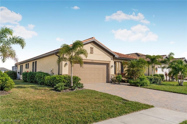 mediterranean / spanish home featuring a front yard and a garage