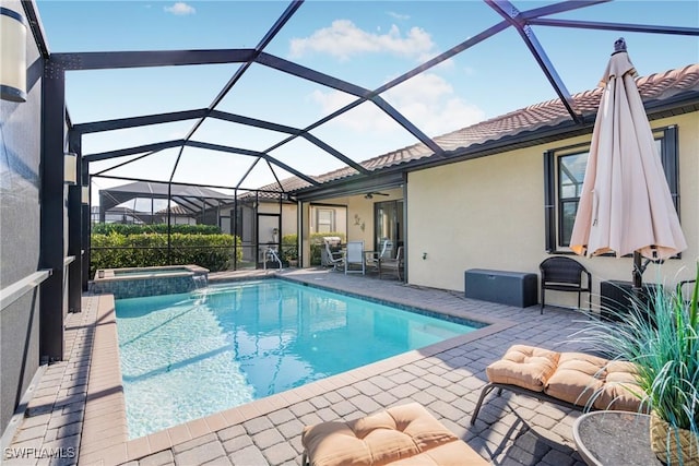 view of pool featuring glass enclosure, an in ground hot tub, and a patio