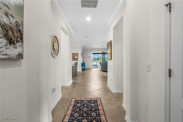 corridor with crown molding and light tile patterned flooring