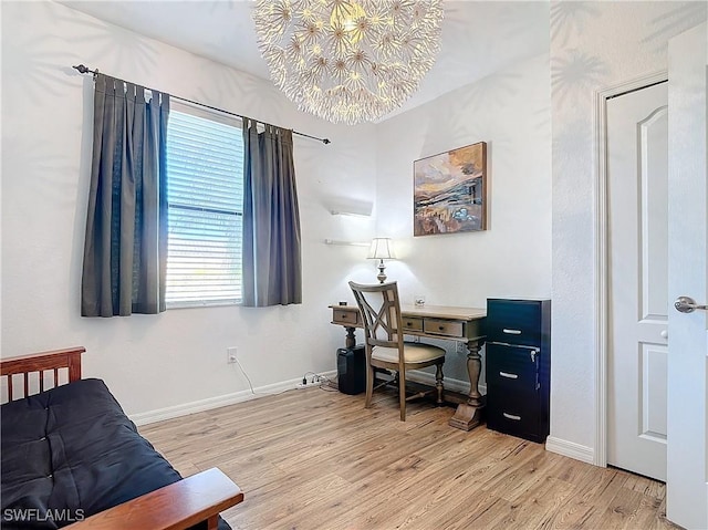 office area with light hardwood / wood-style floors and an inviting chandelier