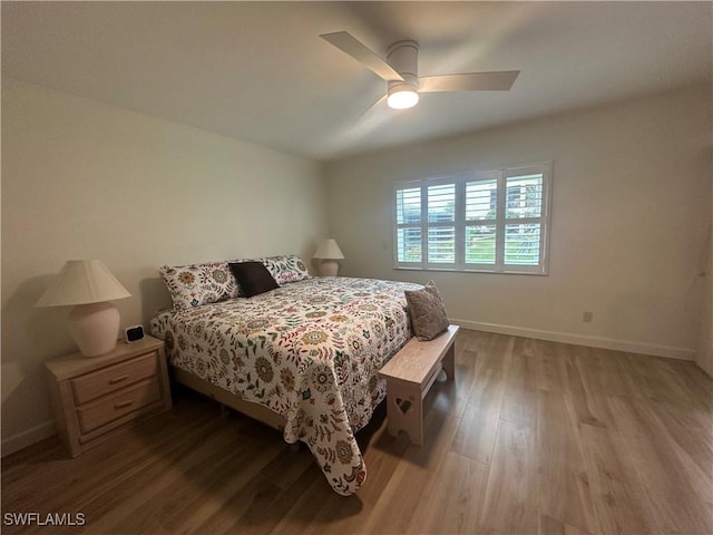 bedroom featuring ceiling fan, baseboards, and wood finished floors