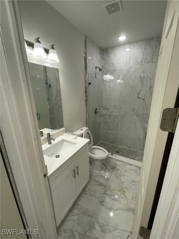 bathroom with vanity, toilet, and a tile shower