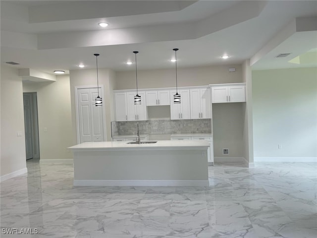 6024 Joplin Ave, Fort Myers, FL 33905 - kitchen with white cabinetry, a sink, a kitchen island with sink, and decorative backsplash