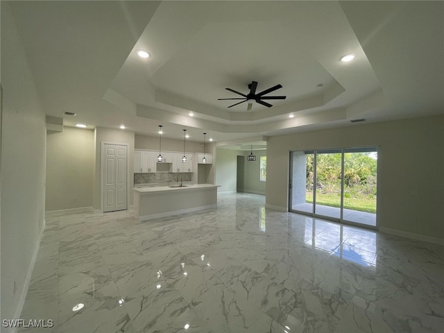 6024 Joplin Ave, Fort Myers, FL 33905 - unfurnished living room with baseboards, a ceiling fan, a sink, and a raised ceiling