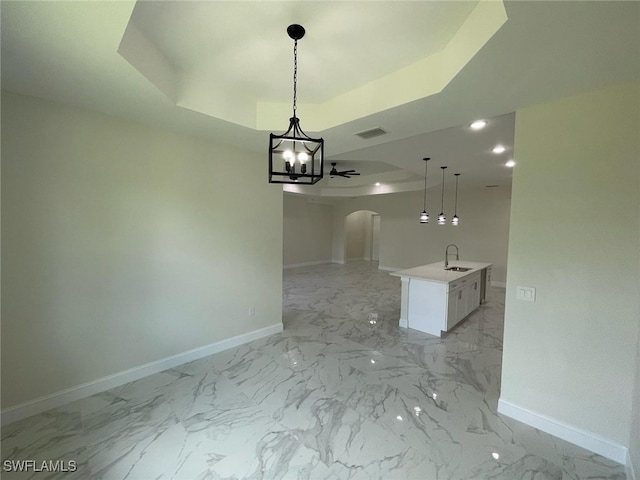 6024 Joplin Ave, Fort Myers, FL 33905 - unfurnished dining area featuring a tray ceiling, an inviting chandelier, baseboards, a sink, and arched walkways