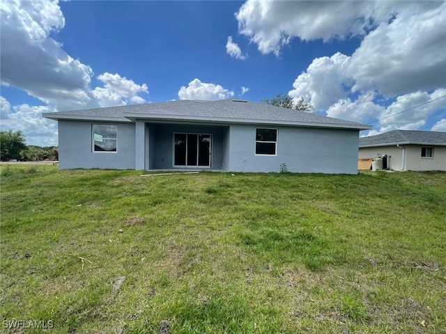 6024 Joplin Ave, Fort Myers, FL 33905 - rear view of house with stucco siding, roof with shingles, and a lawn