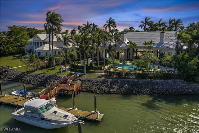 dock area with a lawn and a water view