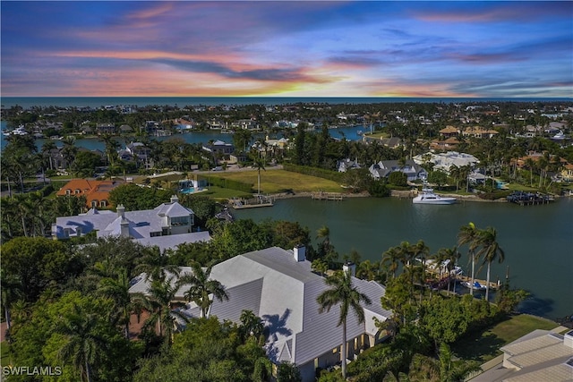 aerial view at dusk featuring a water view