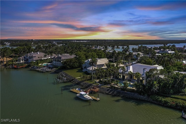 aerial view at dusk featuring a water view