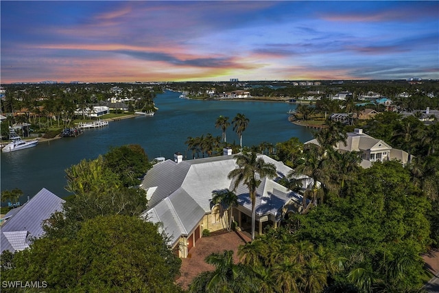 aerial view at dusk featuring a water view