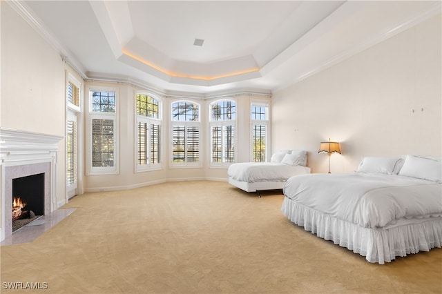 bedroom with a raised ceiling, light carpet, and ornamental molding