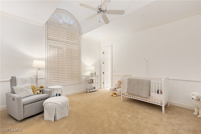 bedroom with carpet floors, a nursery area, and ceiling fan