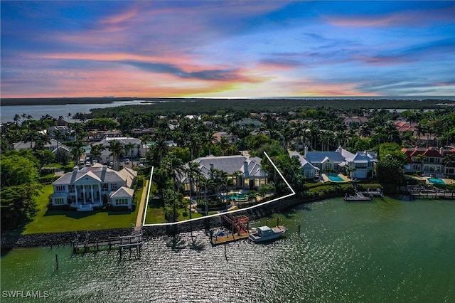 aerial view at dusk featuring a water view