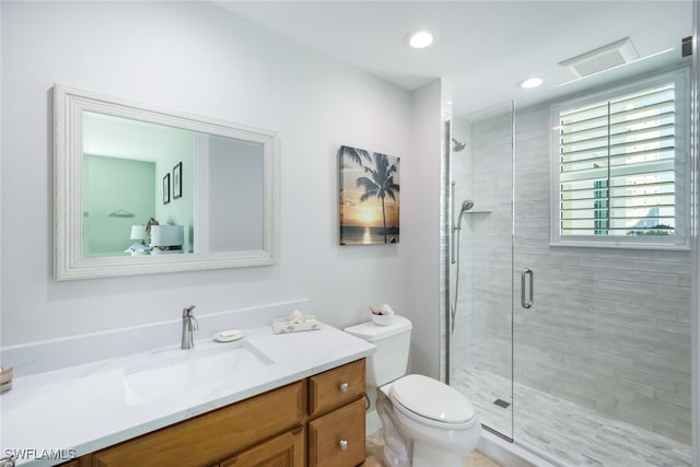 bathroom featuring an enclosed shower, vanity, and toilet