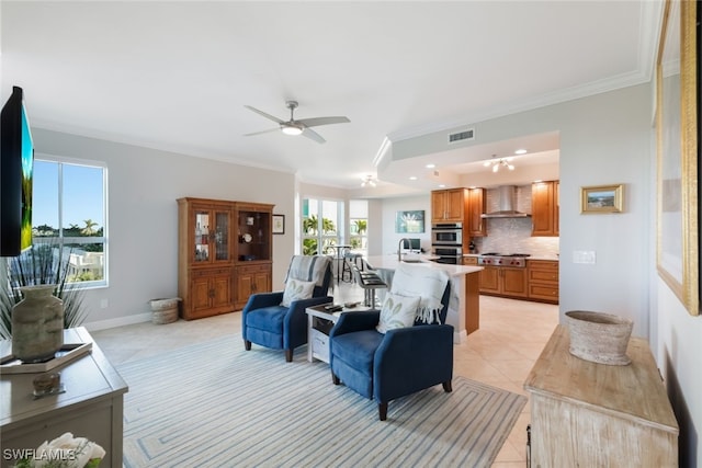 living room featuring ceiling fan, light tile patterned floors, and crown molding