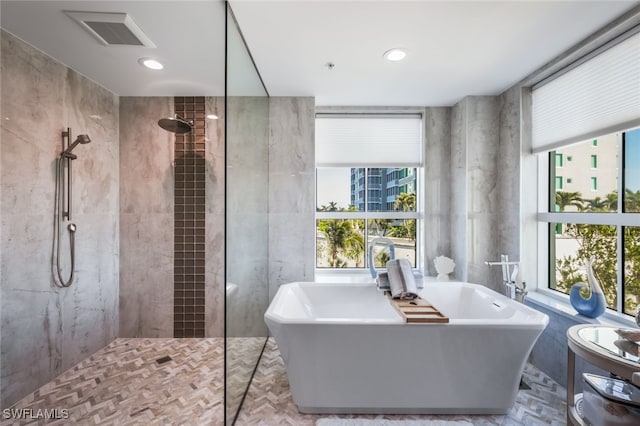 bathroom featuring shower with separate bathtub and a healthy amount of sunlight