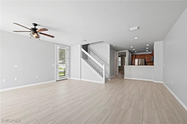 unfurnished living room with ceiling fan and light wood-type flooring