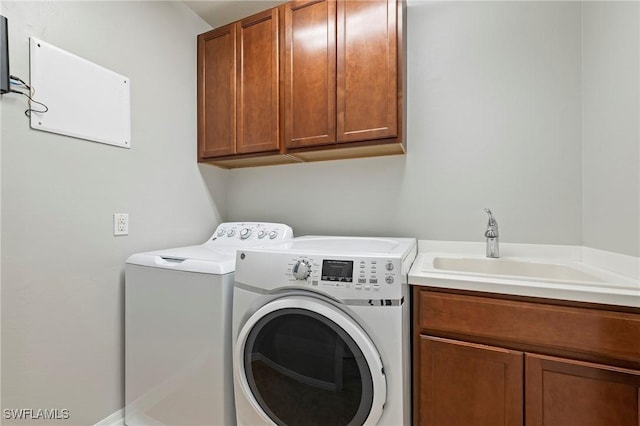 laundry area with cabinets, separate washer and dryer, and sink