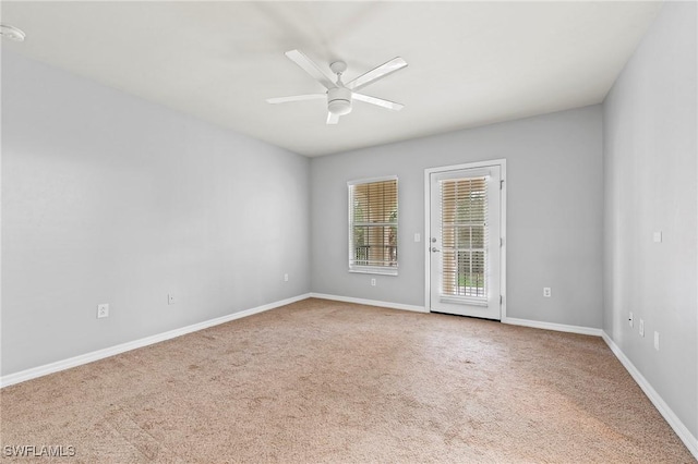 carpeted spare room featuring ceiling fan