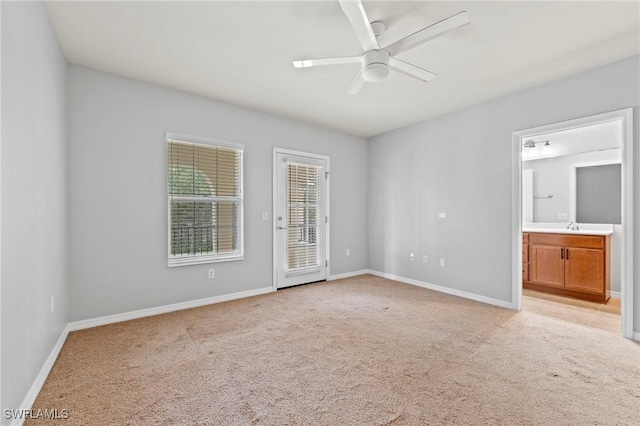 spare room featuring sink, light colored carpet, and ceiling fan