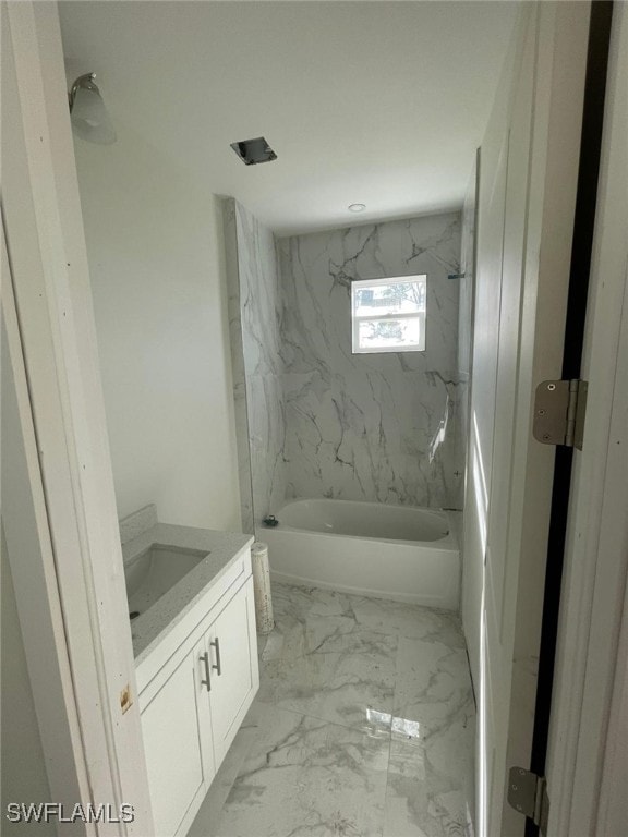 bathroom featuring vanity and tiled shower / bath