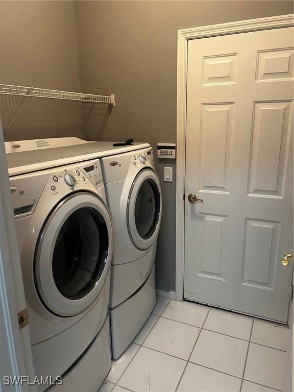 washroom featuring independent washer and dryer and light tile patterned flooring