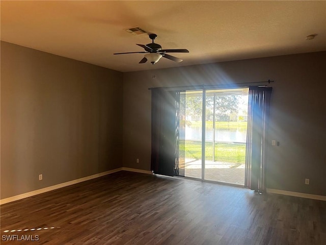 spare room featuring dark hardwood / wood-style flooring and ceiling fan