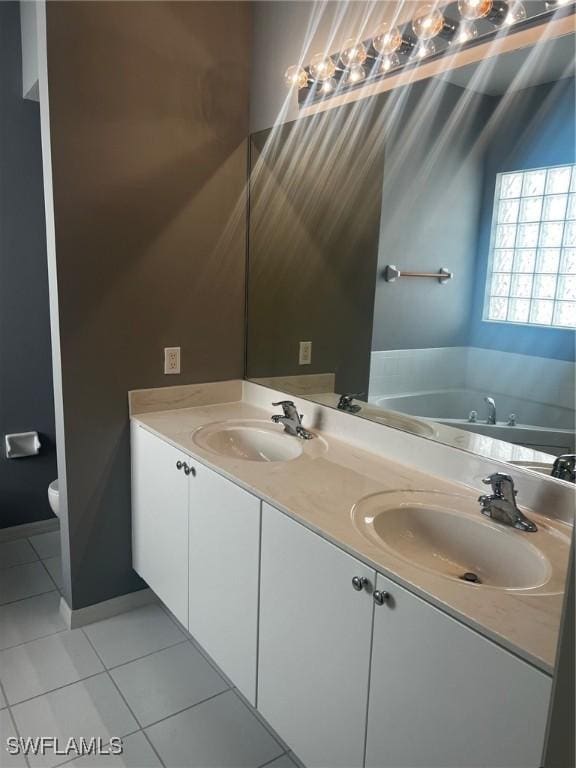 bathroom with toilet, vanity, tile patterned floors, and a bathing tub