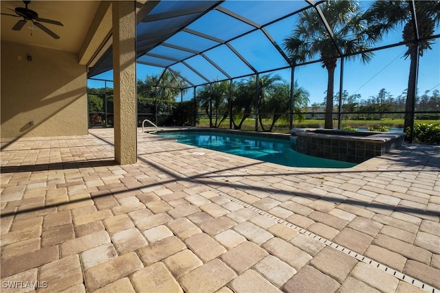 view of swimming pool with glass enclosure, ceiling fan, a patio area, and an in ground hot tub