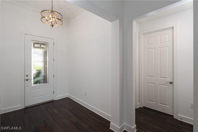 foyer featuring dark hardwood / wood-style flooring, a notable chandelier, and ornamental molding