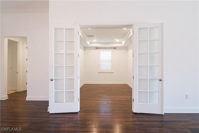 unfurnished room with crown molding, dark wood-type flooring, a tray ceiling, and french doors