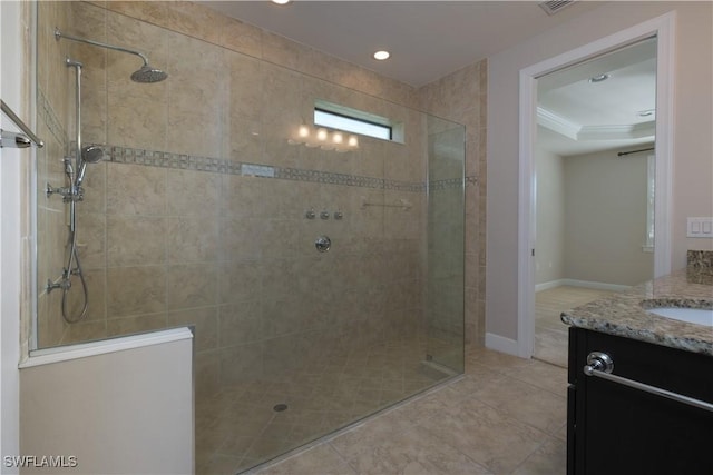 bathroom with tile patterned flooring, vanity, a tile shower, and crown molding